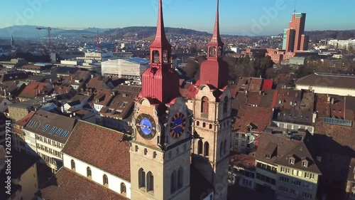 Drone flight with aerial view above church in old town of Winterthur in Switzerland. Tower and building roofs from above. Dynamic, stabilized and smooth shots of European town.