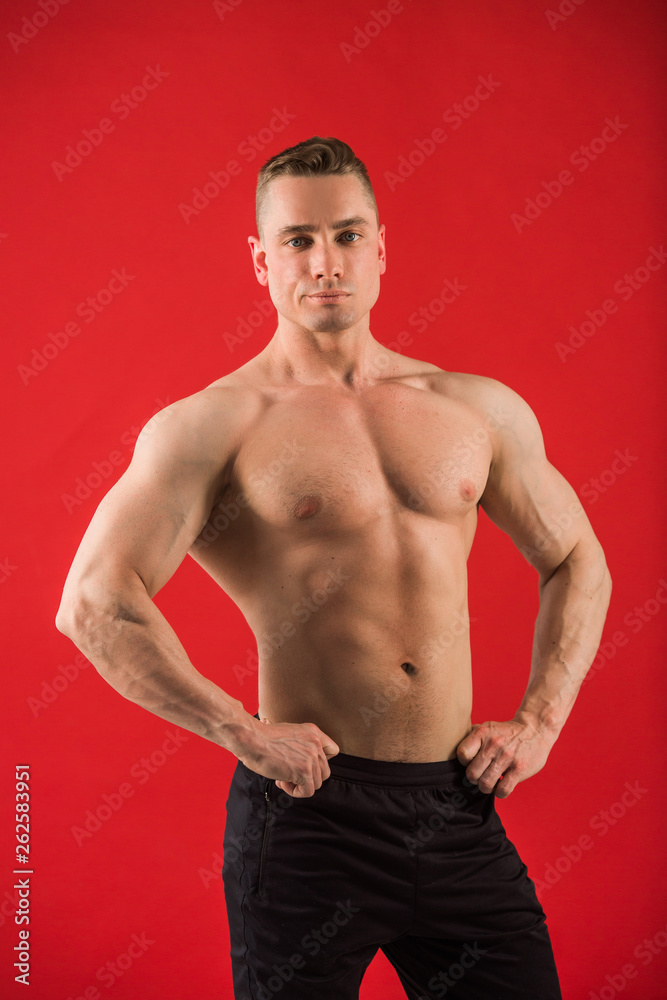 handsome young man in athletic uniform on red background