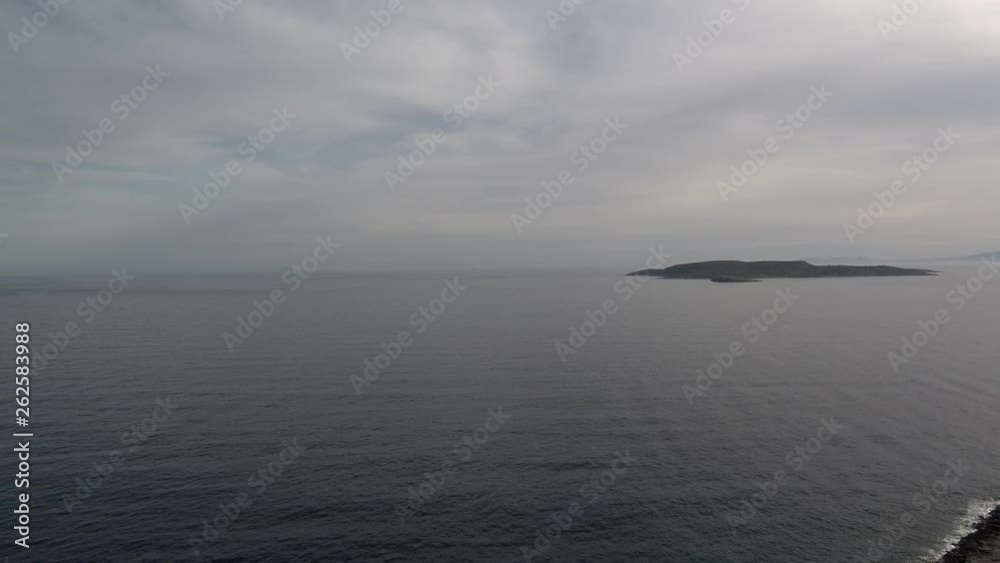Aerial shots of a sunset behind grey clouds. Flying slowly above dark sea water. Aerial shots of a sunset behind grey clouds. Flying slowly above dark sea water.