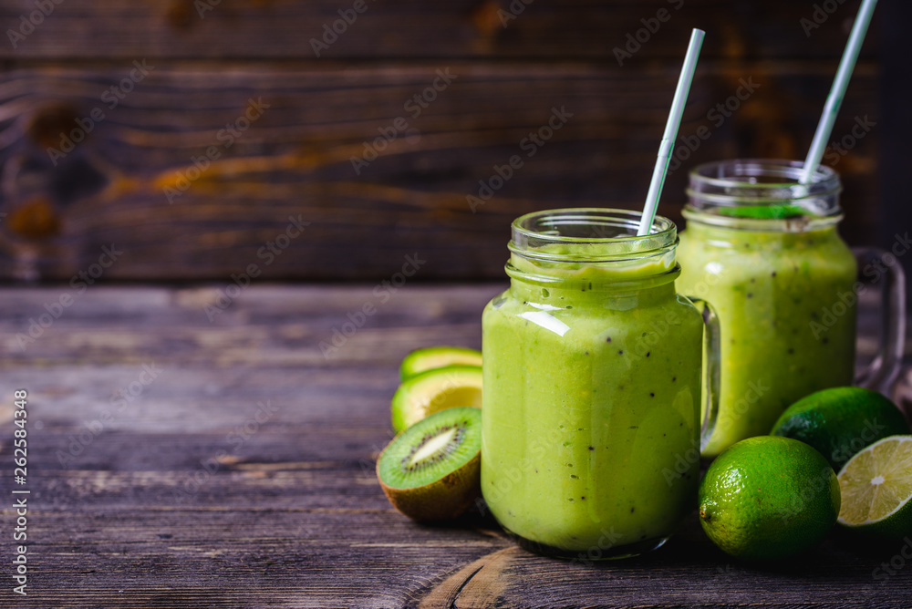 Green smoothie made by avocado, lemon and kiwi on natural wooden background. Green smoothie made by avocado, lemon and kiwi on natural wooden background.