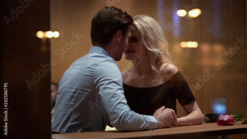 Canvas Print Blond woman sitting in restaurant and flirting with handsome man, relationship