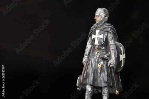 Fototapeta Naklejka Na Ścianę i Meble -  Toy figure knight with an ax and a shield on a black background.