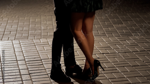 Loving couple hugging and kissing in the street, view of legs, relationship