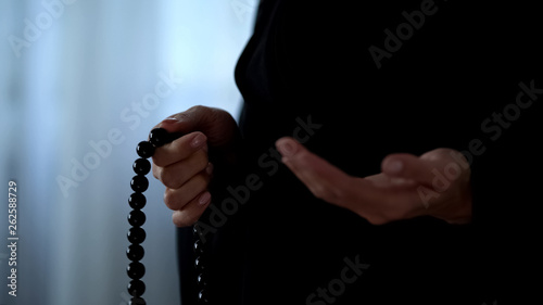 Muslim woman praying with islamic beads in hand, religious meditation, worship