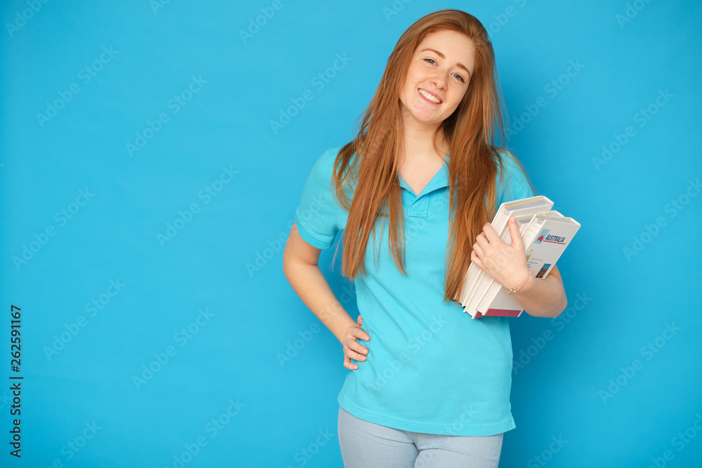 Happy girl holding books. Isolated on blue background. Happy girl holding books. Isolated on blue background.