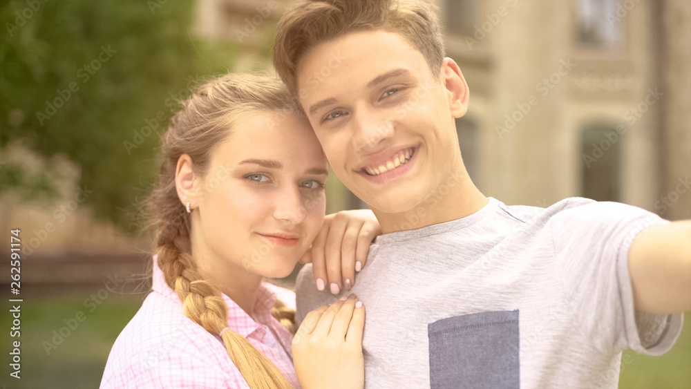 Cheerful teenagers smiling at camera, making memorable photo of sweet moment