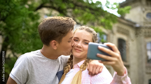 Couple of teens making selfie, boy kissing girl, photo for personal blog, love