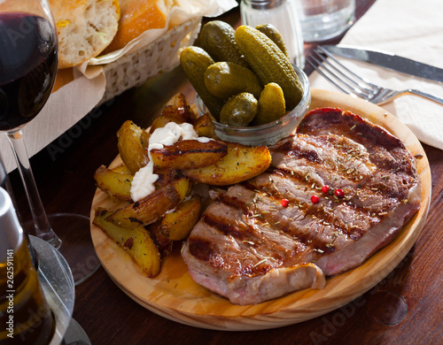 Appetizing beef entrecote with boiled potatoes and pickled cucumbers