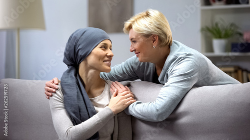 Smiling woman with cancer hugging mother, hope and togetherness, remission photo