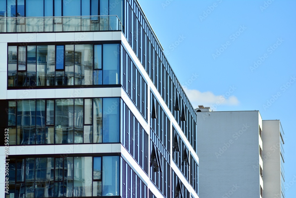 Modern office building wall made of steel and glass with blue sky Modern office building wall made of steel and glass with blue sky