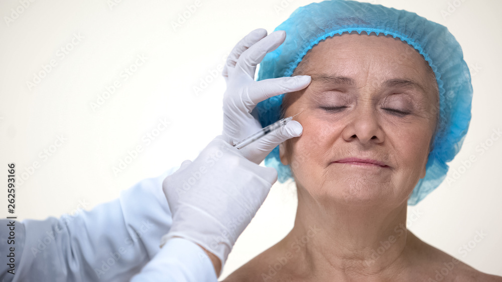 Doctor hands making facial injections for aging female patient, dermatology Doctor hands making facial injections for aging female patient, dermatology