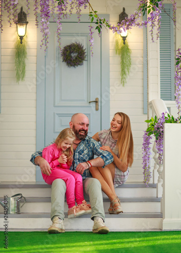 Young happy family having fun in courtyard of the summer house © okostia