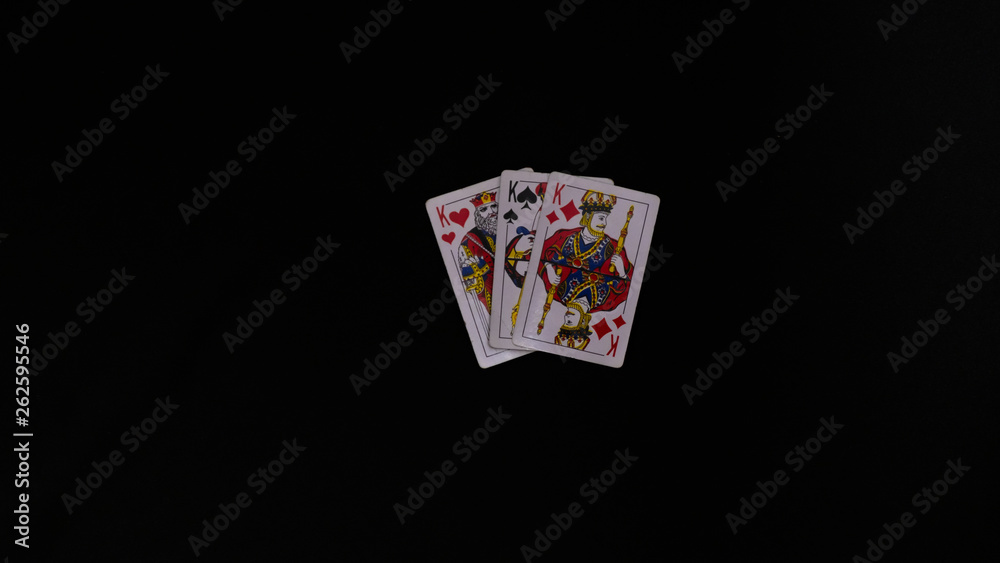 playing cards on a black table, hands holding cards playing cards on a black table, hands holding cards