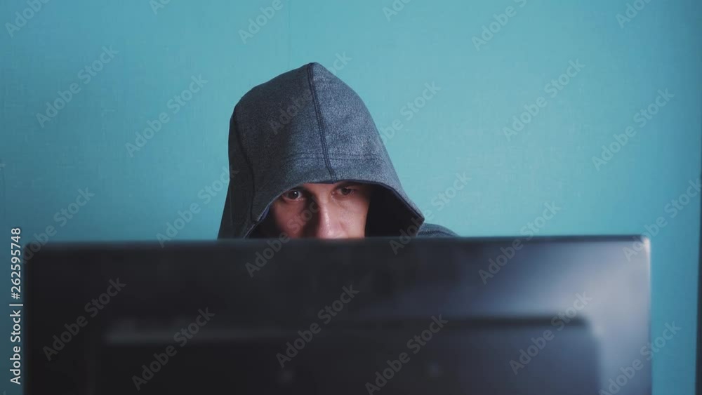 man hacker in the hood hacking network concept. lifestyle unknown hacker criminal breaks into computer protection on the Internet passwords. male hacker penetrates into hack network protection web man hacker in the hood hacking network concept. lifestyle unknown hacker criminal breaks into computer protection on the Internet passwords. male hacker penetrates into hack network protection web