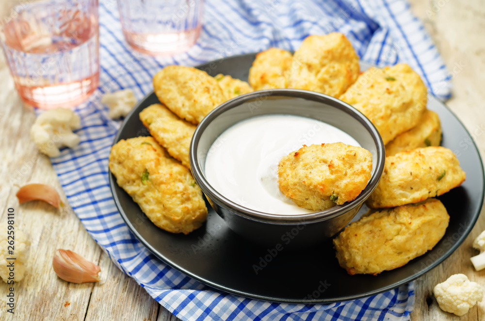 Baked cauliflower Tots on a wood background Baked cauliflower Tots on a wood background