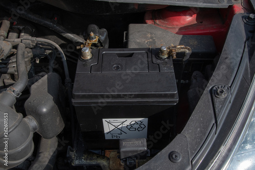 New car battery in car with cables connected to terminals
