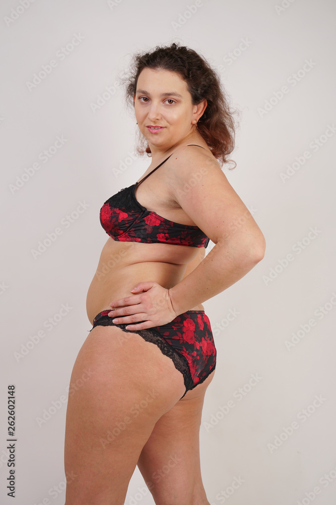 feminine chubby woman with plus size body in black lingerie posing on white  background in Studio Stock Photo | Adobe Stock