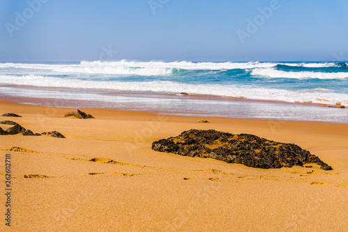 Landscape of Adraga sandy beach with stones, Portugal coast of Atlantic ocean photo