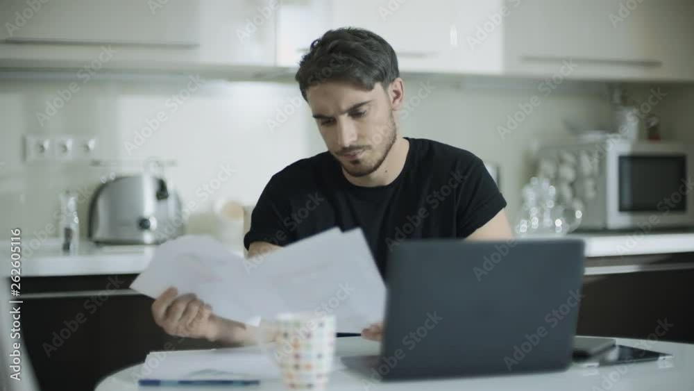 Thoughtful man working with documents at home. Business man doing paperwork Thoughtful man working with documents at home. Business man doing paperwork