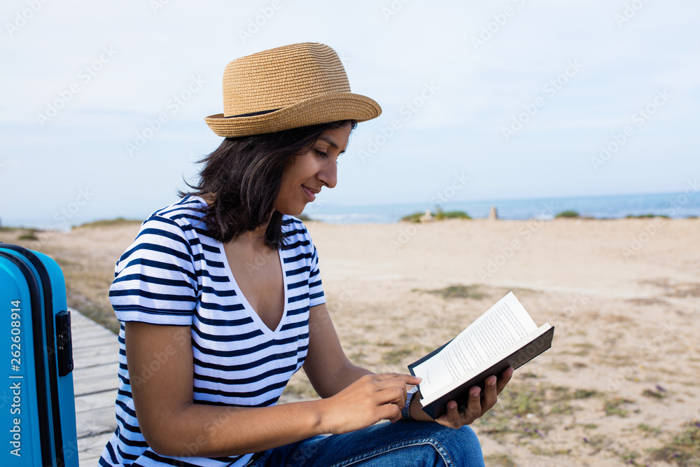 Young indian woman reading a book in the countryside