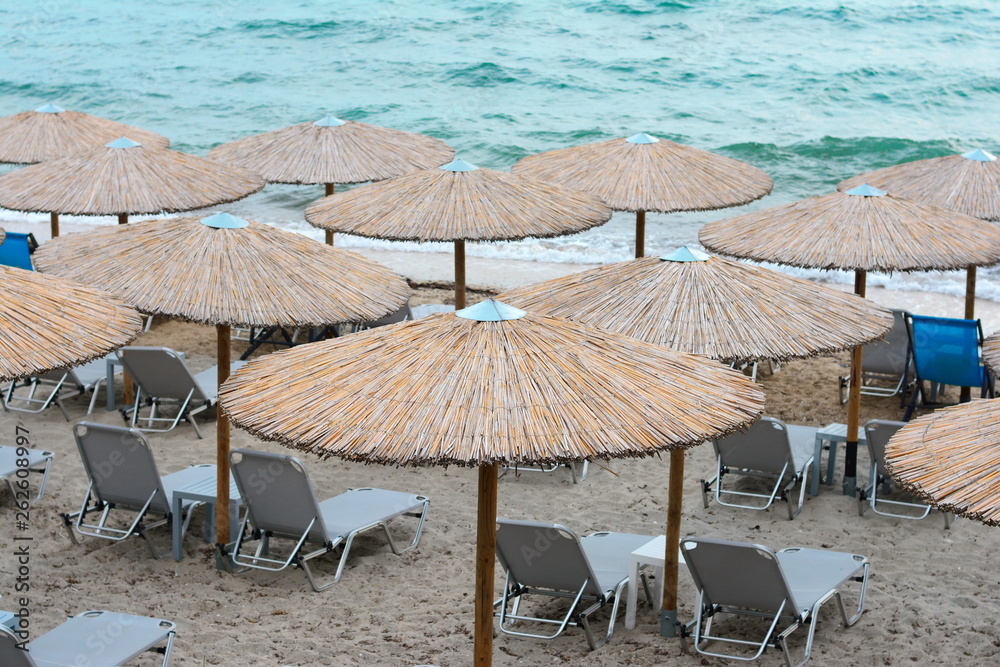 Beach umbrellas woven from cane on a sandy beach