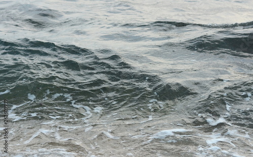 Beautiful soft waves of Blue Ocean with Sandy Beach Background close up. Sea sand wallpaper