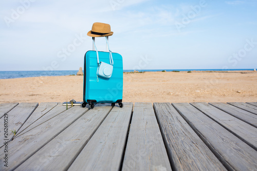 Close-up of blue luggage in front of the sea