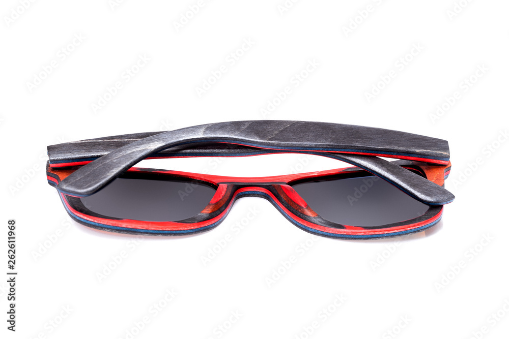70s style square sunglasses wooden case of red and gray arms with the texture of wood and black tinted glass rear view lies on white backgrond. 70s style square sunglasses wooden case of red and gray arms with the texture of wood and black tinted glass rear view lies on white backgrond.