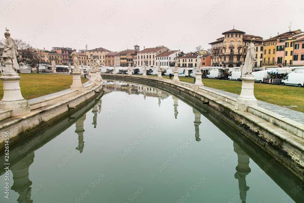 Statues reflect on canal water in Prato della Valle Square in Padua, Italy