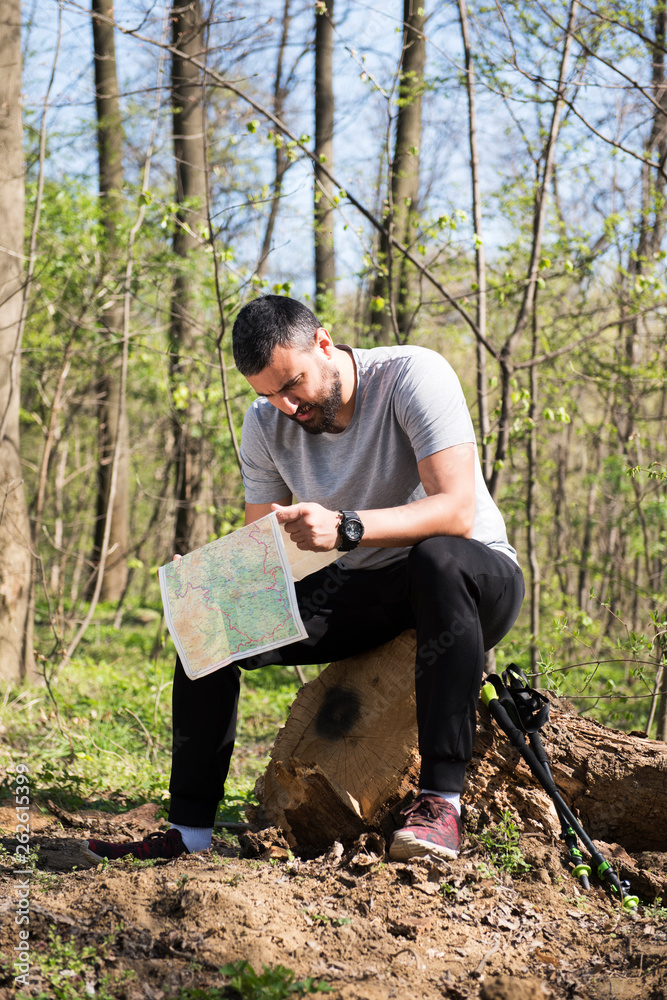Male hiker using a map to locate the destination Male hiker using a map to locate the destination