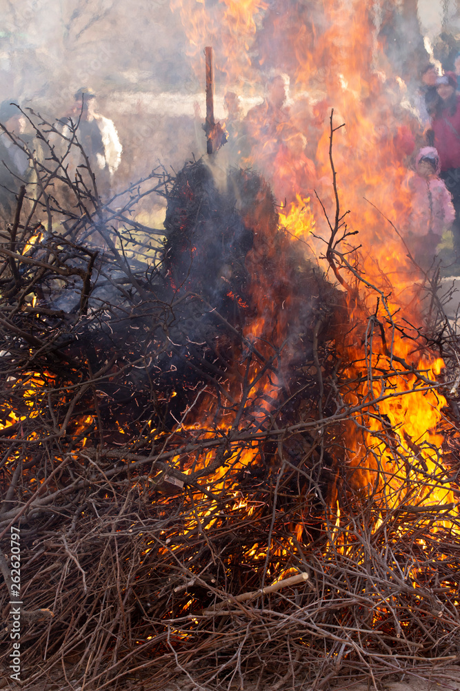 Flaming fire. Burning tree branches. Pagan rite dedicated to the arrival of spring. Big bonfire on Shrovetide. Flaming fire. Burning tree branches. Pagan rite dedicated to the arrival of spring. Big bonfire on Shrovetide.