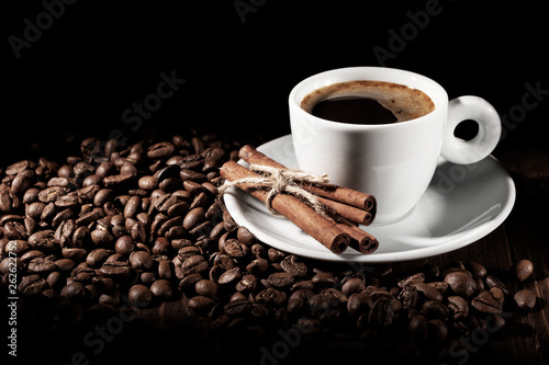 Cup of coffee with coffee beans and cinnamon sticks