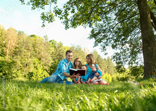  young family reading the Bible in nature