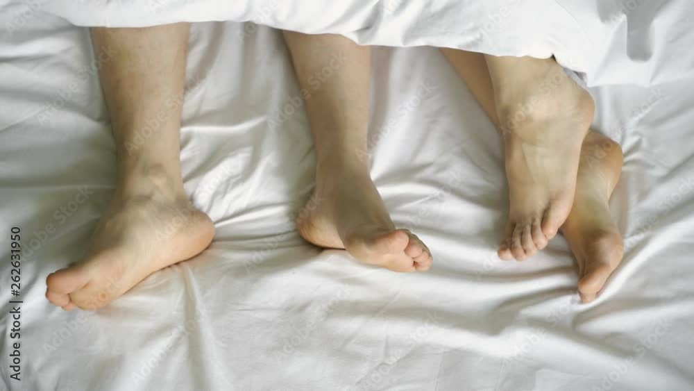 Vidéo Stock couple in bed making love. male and female legs top view