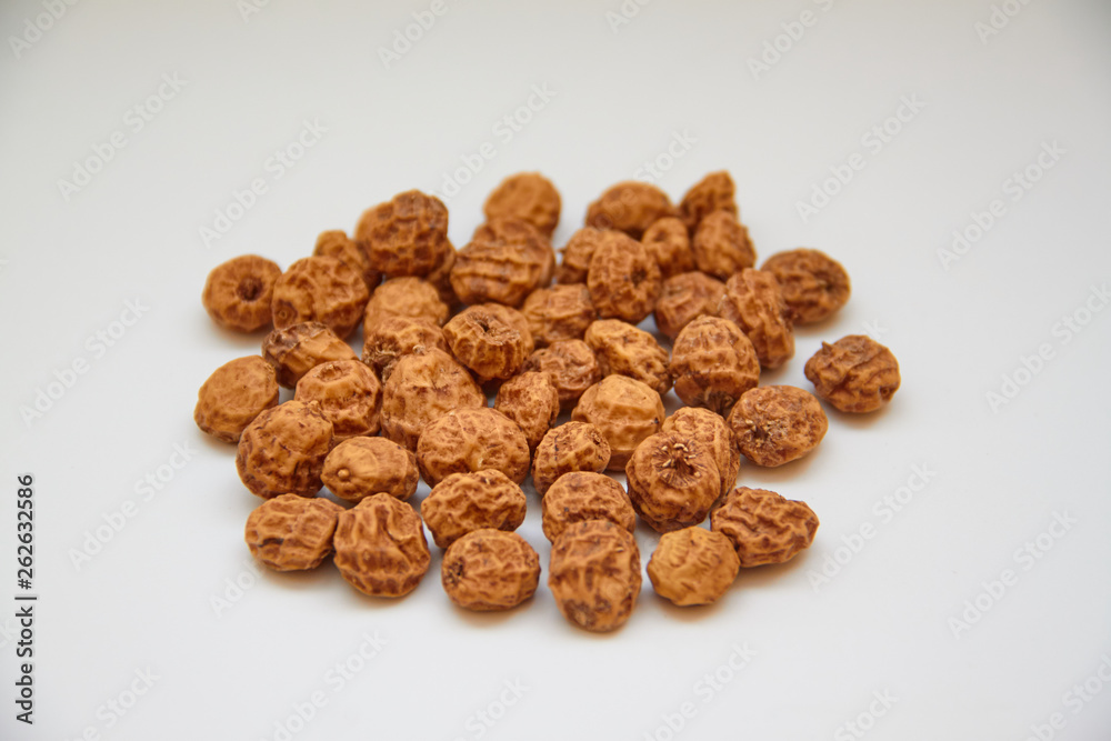 Side view of a pile of insulated tigernuts on a white background. The Spanish tigernut is called chufa