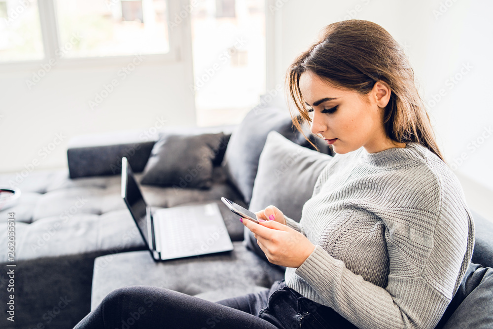 Young woman using smart phone mobile at home, text message sending communication reading mail social network app Young woman using smart phone mobile at home, text message sending communication reading mail social network app