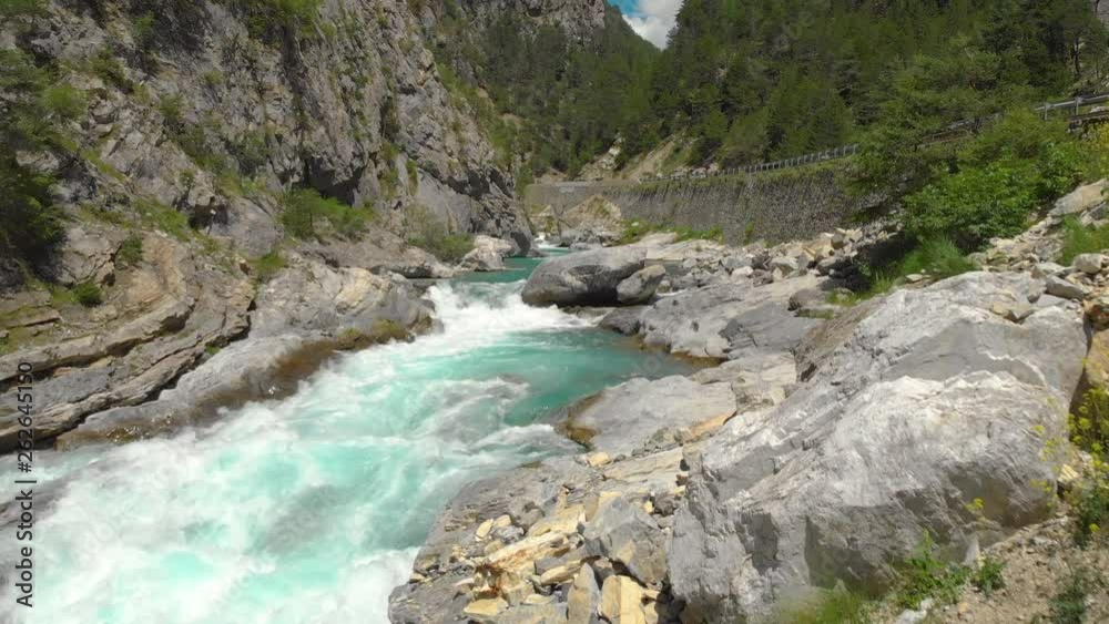 AERIAL: Flying above the stunning emerald river while tourist cars drive along the powerful rapids. Scenic shot of the beautiful mountain river running alongside a scenic road in the French Alps. AERIAL: Flying above the stunning emerald river while tourist cars drive along the powerful rapids. Scenic shot of the beautiful mountain river running alongside a scenic road in the French Alps.