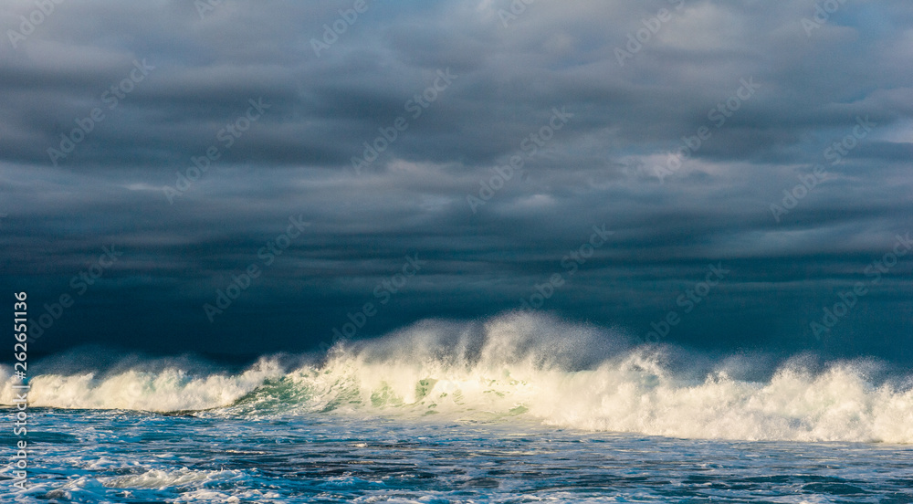 Powerful ocean wave breaks on a shallow bank. Stormy weather. Seascape.