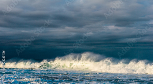 Powerful ocean wave breaks on a shallow bank. Stormy weather. Seascape.