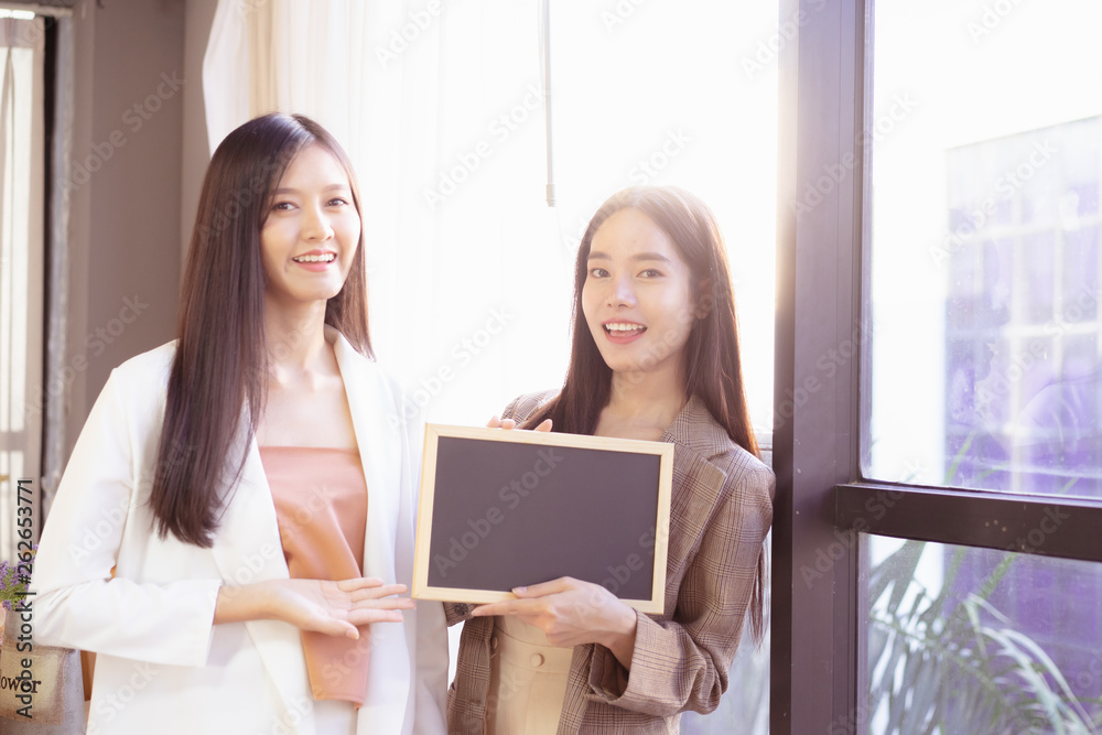 young Asian business woman holding a chalkboard.Successful business woman happy and smile.Idea note on blank blackboard. young Asian business woman holding a chalkboard.Successful business woman happy and smile.Idea note on blank blackboard.