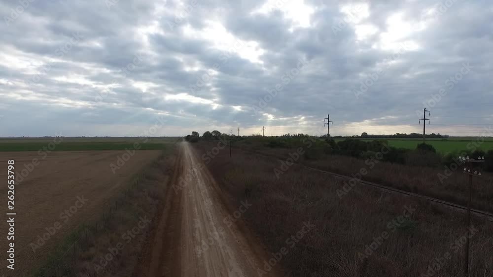 Drone shot of a dust pick up cloud moving away down a dirt road in the countryside Drone shot of a dust pick up cloud moving away down a dirt road in the countryside