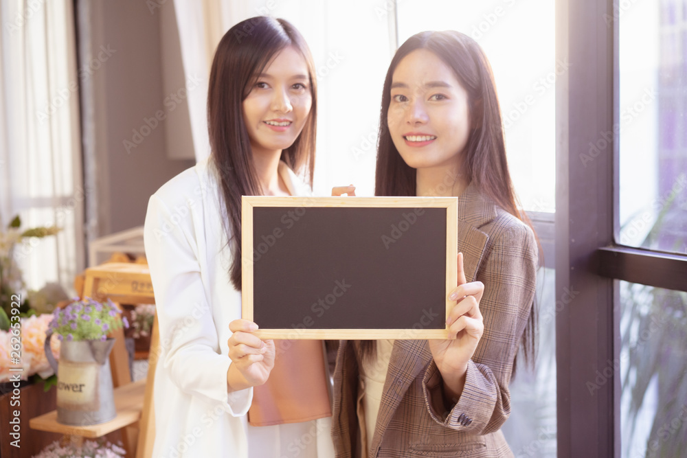 young Asian business woman holding a chalkboard.Successful business woman happy and smile.Idea note on blank blackboard.