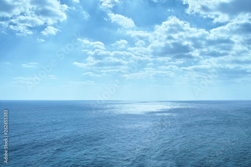 雲の切れ間より太陽光線が海面を照らす風景