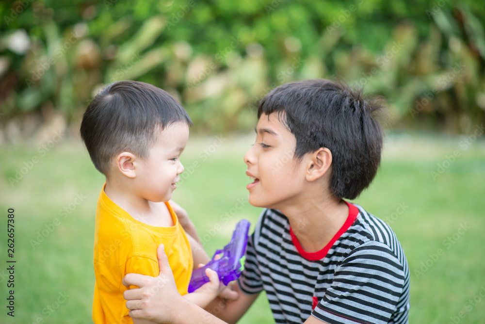 Little Asian toddle talking with brother at playground Little Asian toddle talking with brother at playground