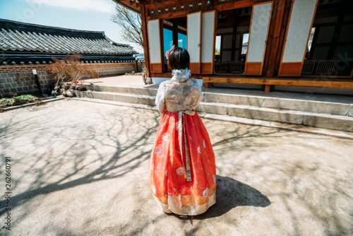Young woman traveler in traditional korean dress or call hanbok traveling into Bukchon Hanok Village at Seoul city in South Korea
