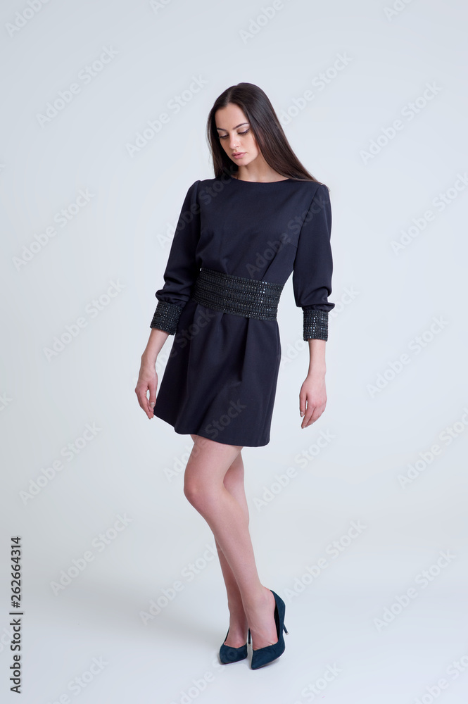 Portrait of the beautiful brunette girl in short blue dress