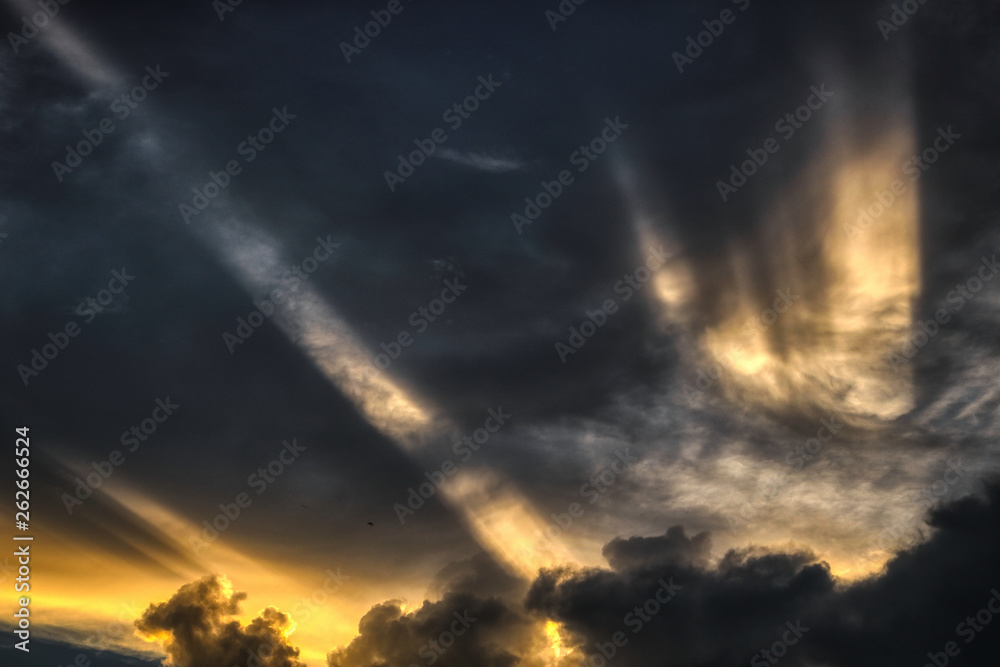 Naklejka premium Dieses einzigartige Foto, das in der Stadt Hua Hin in Thailand aufgenommen wurde, zeigt, wie sich die Sonnenstrahlen der Abendsonne durch die Wolkendecke bewegen