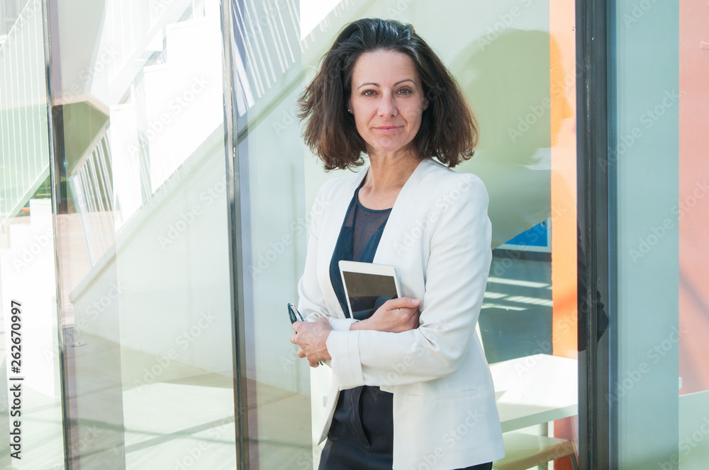 Serious woman holding phone and tablet in hands Serious woman holding phone and tablet in hands