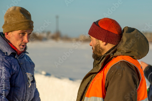Two workers in overalls at a construction site