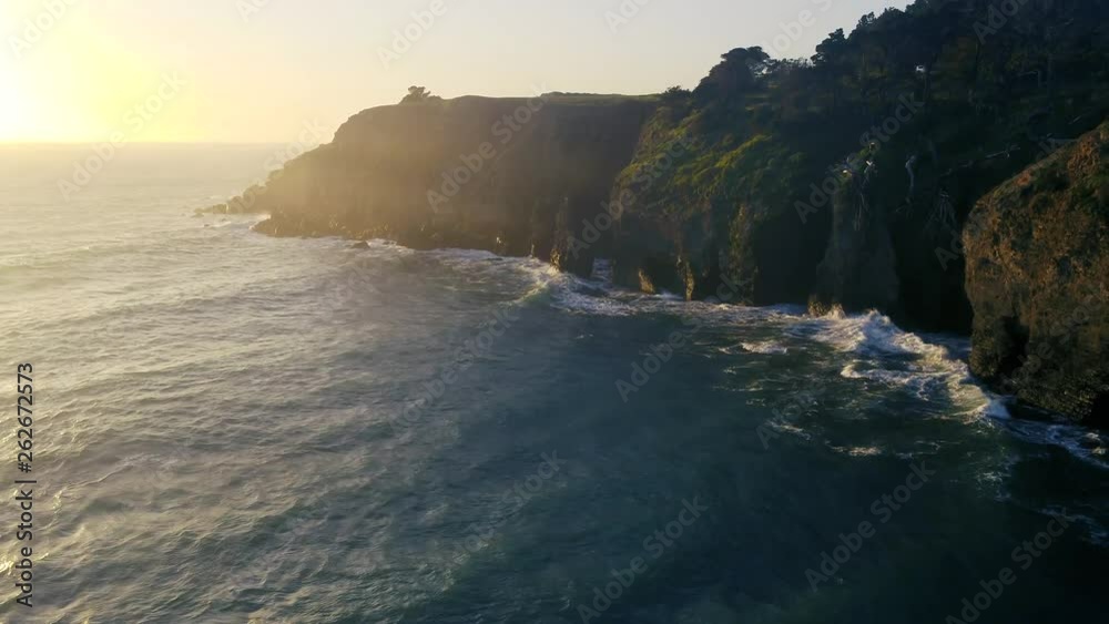 Drone captures a setting sun at golden hour over a lonely cove. Haze and setting sun create a dreamy and surreal vibe. Drone captures a setting sun at golden hour over a lonely cove. Haze and setting sun create a dreamy and surreal vibe.